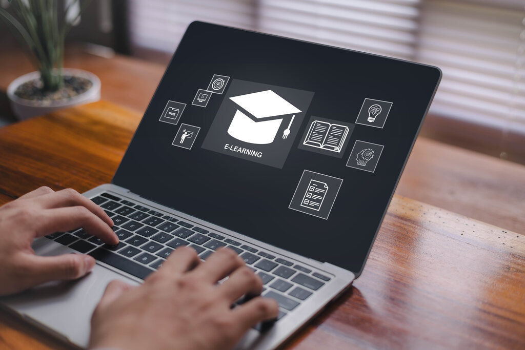 Detalhe de mãos utilizando notebook para realizar cursos sobre benefícios para pequenas empresas.