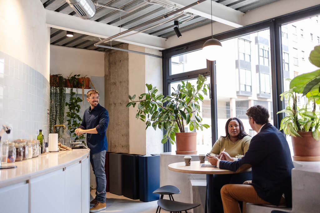 Três pessoas em horário de café, aproveitando benefícios voltados ao perfil dos colaboradores.