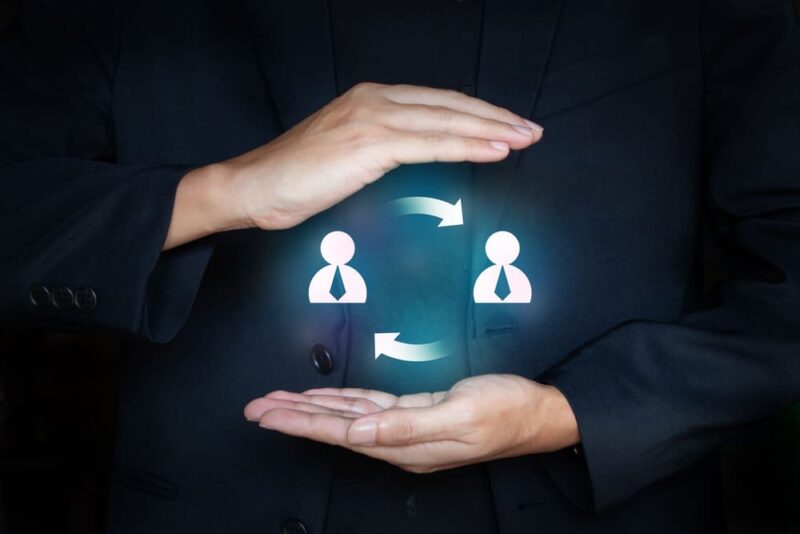Ilustração conceitual de turnover com duas figuras conectadas por setas circulares, simbolizando a rotatividade de colaboradores e a dinâmica de entradas e saídas na empresa.